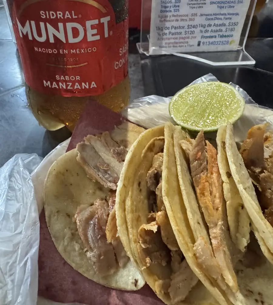 Tacos al pastor recién servidos con una rodaja de limón, en un puesto de la Ciudad de México