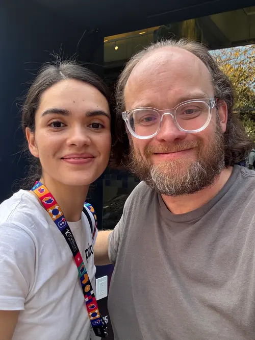 Esteban Rey y una mujer posan juntos al aire libre.