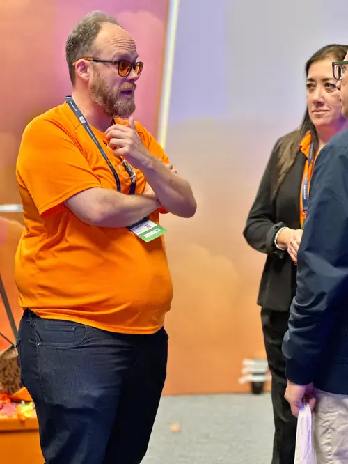 Esteban Rey habla en una conferencia con su característica camiseta naranja.