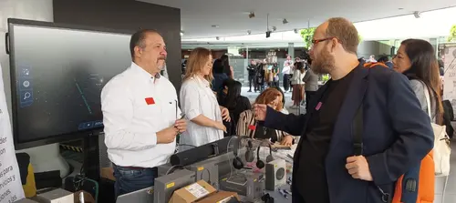 Esteban Rey habla en un evento con su característica camiseta naranja.