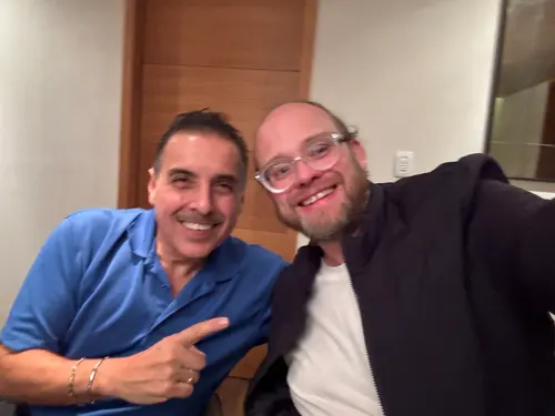 Esteban Rey y un amigo sonríen juntos en un espacio de oficina.