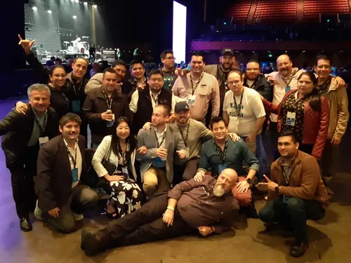 Esteban Rey y amigos posan en un escenario junto a una banda de rock.