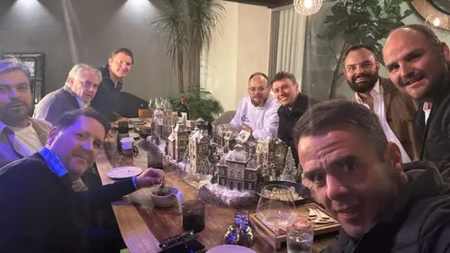 Esteban Rey comparte cena con amigos en una mesa larga con villas de nieve y vino.